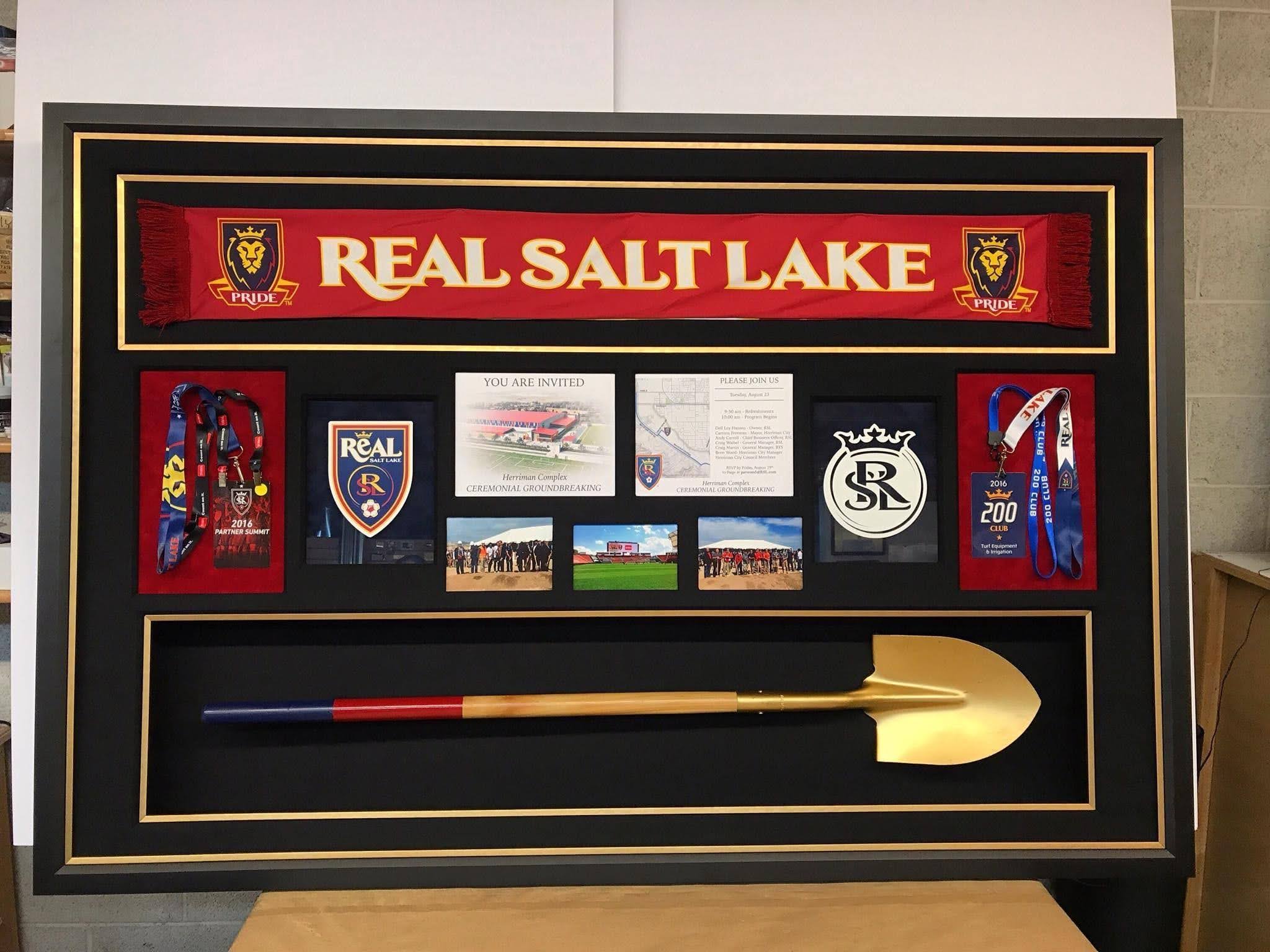 A framed image depicting Real Salt Lake with a shovel and assorted objects displayed beside it
