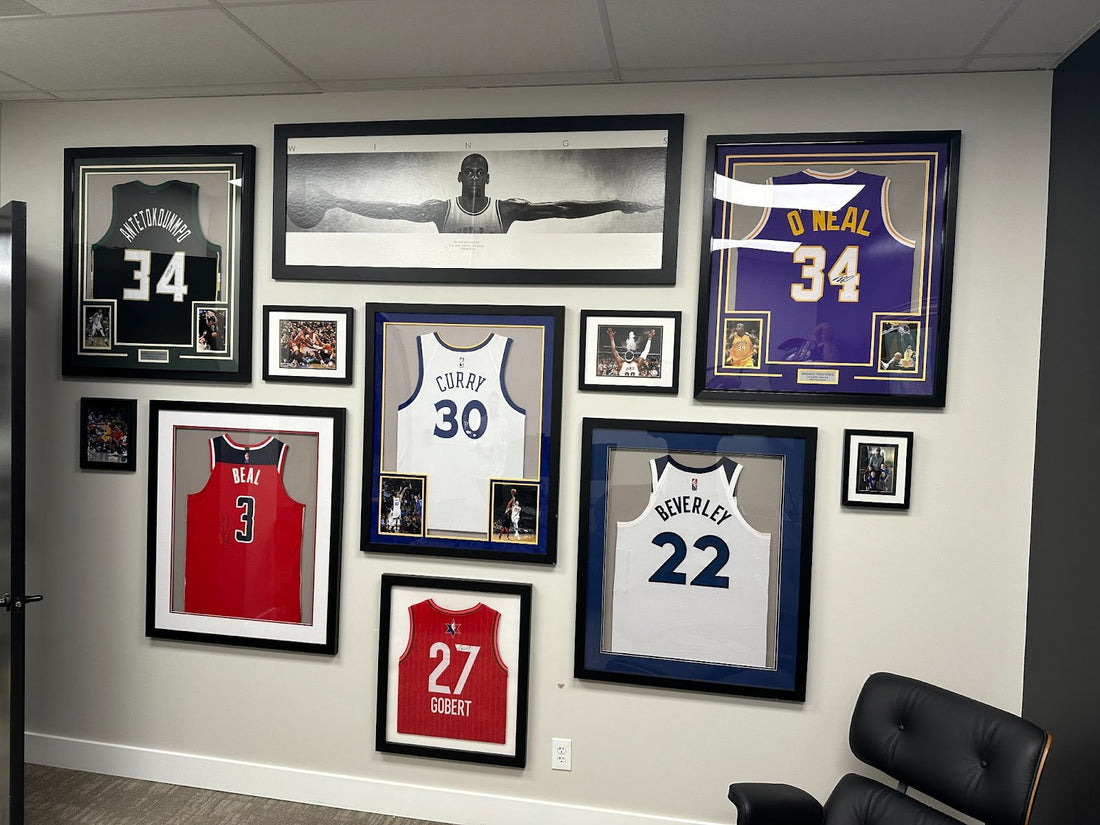 Framed NBA jerseys Antetokounmpo #34, O'Neal #34, Curry #30, Beal #3, Beverley #22, Gobert #27. Center Michael Jordan Wings poster.