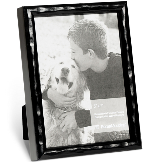 Black-framed photo shows a boy kissing a smiling dog. The emotional scene conveys warmth and affection. The frame is labeled "5x7" by Roma Moulding.