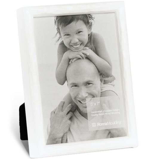 Black and white photo of a smiling man with a child on his shoulders, inside a white frame. The child grins playfully, conveying joy and warmth.