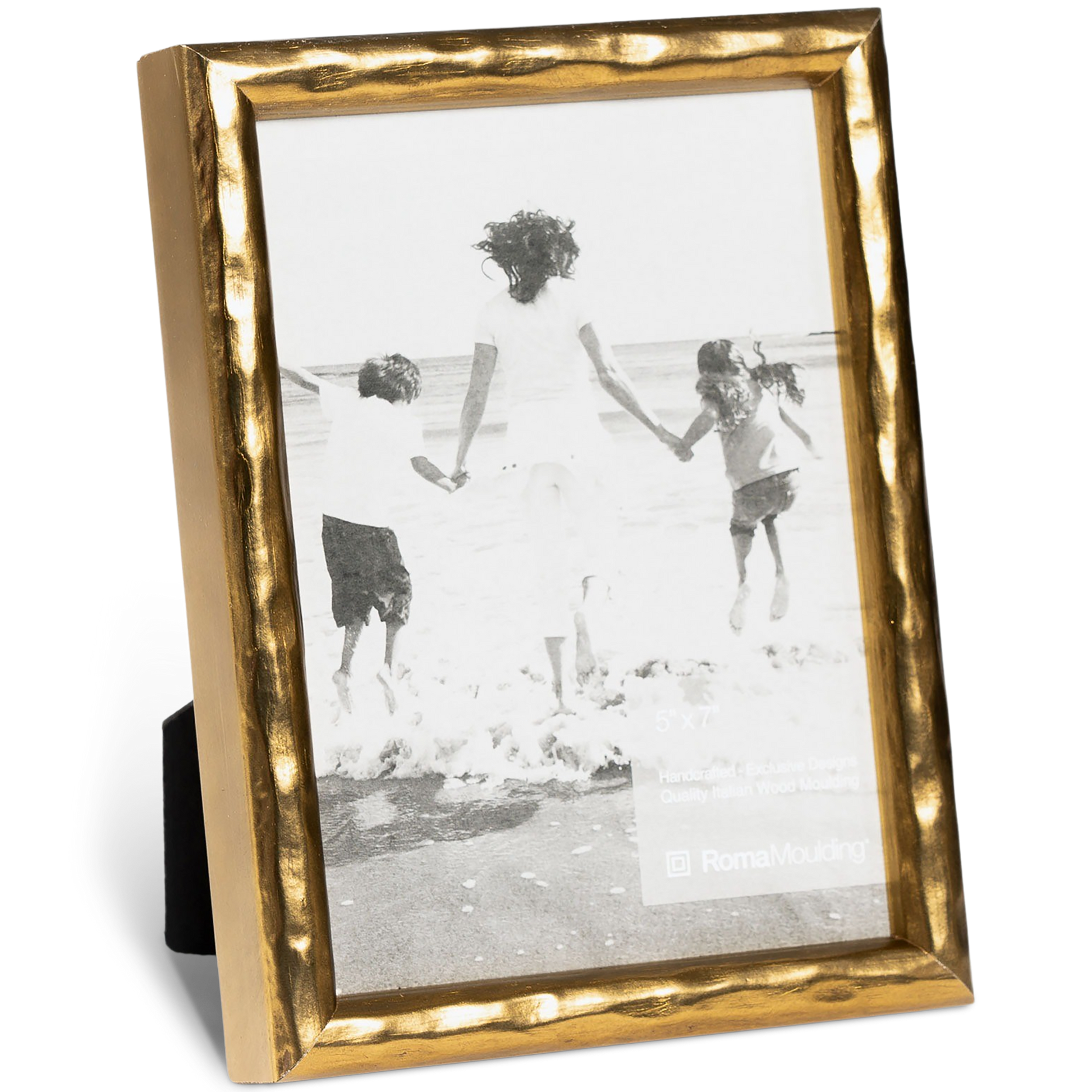 A photograph in a textured gold frame shows three people, two children and an adult, joyfully jumping on a beach, holding hands, with ocean waves in the background.