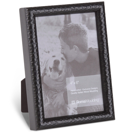 Black, textured photo frame displaying a grayscale image of a boy affectionately kissing a smiling dog. The mood is heartwarming and tender.