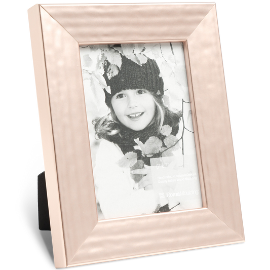Framed black and white photo of a smiling child in a knit hat, surrounded by fall leaves. The rose gold frame adds warmth and elegance.