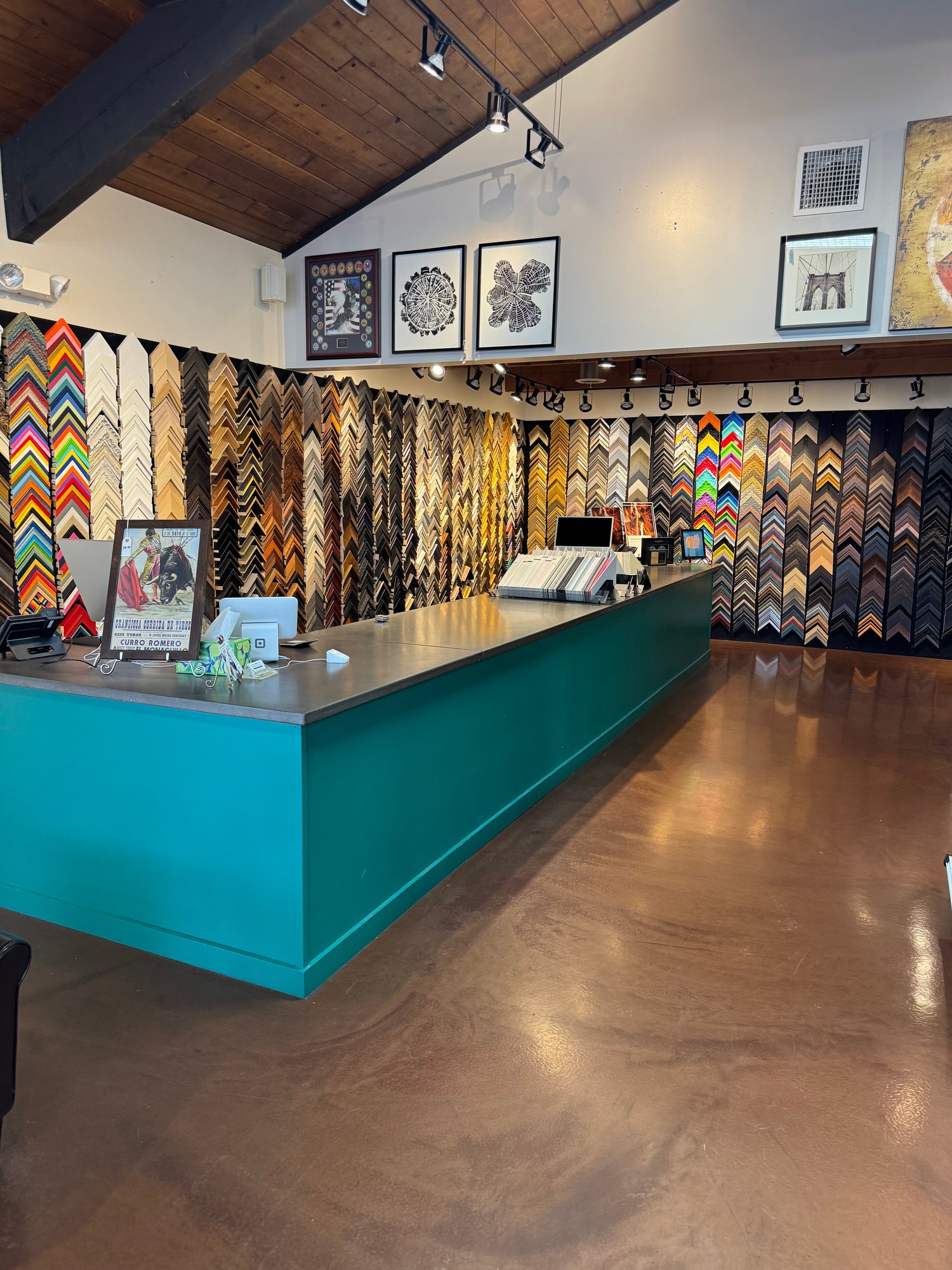 Display of picture frames in a store with a teal counter.