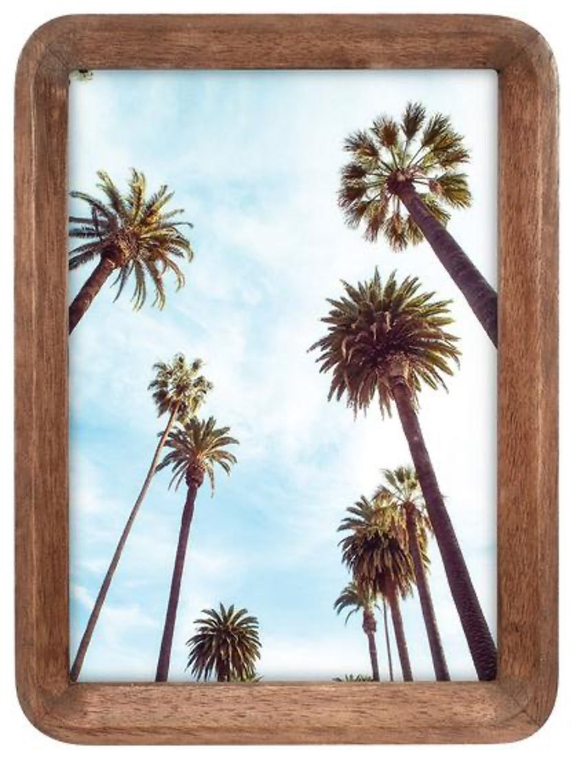 Wooden picture frame with a palm tree scene on a white background