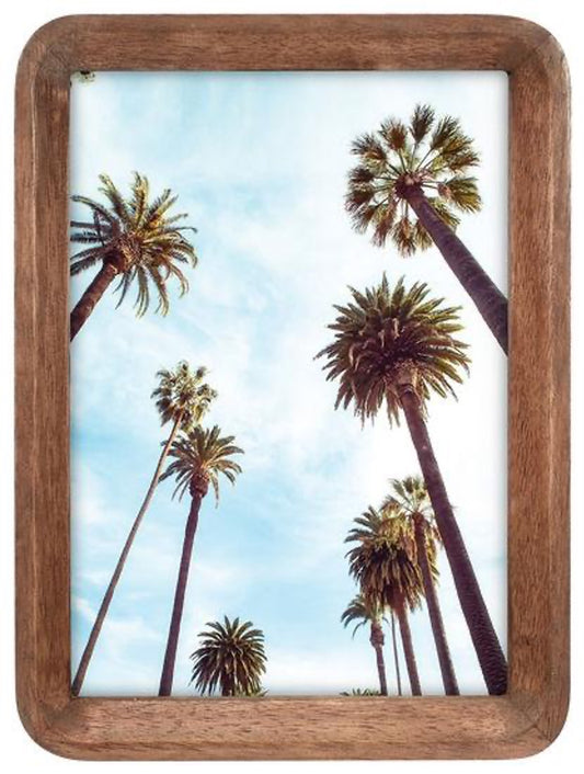 Wooden picture frame with a palm tree scene on a white background