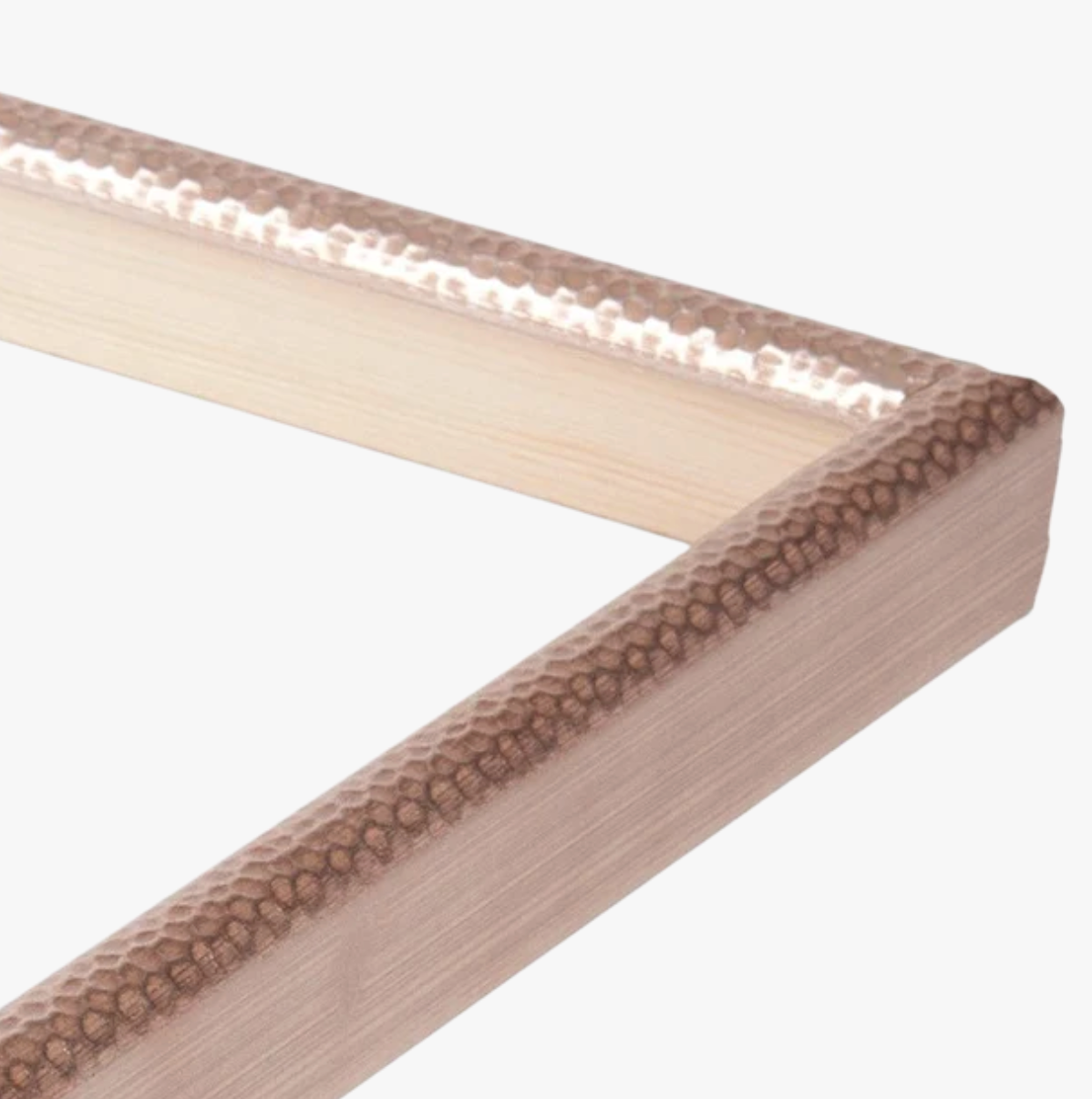 Close-up of a corner of a textured wooden picture frame. The frame has a hammered metallic finish, creating a rustic and elegant appearance.