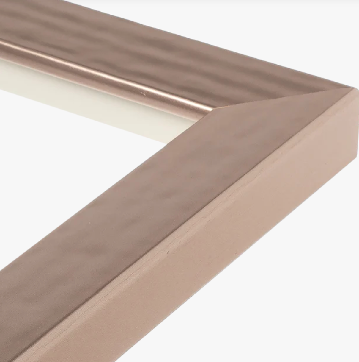 Close-up of a sleek, bronze-colored picture frame corner with a beveled edge and smooth, reflective surface, conveying a modern and elegant tone.