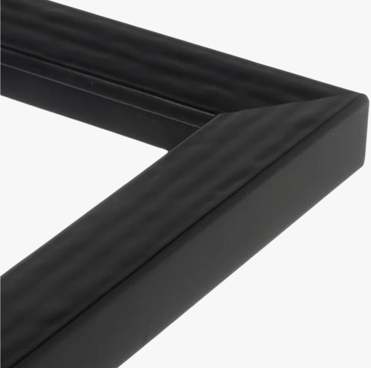 Close-up of a black picture frame corner with a textured, matte finish. The simple, modern design conveys a sleek and minimalist style.