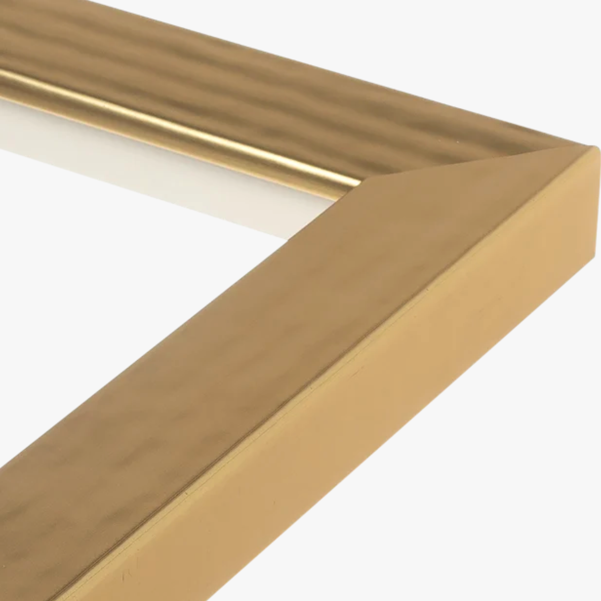 Close-up of a gold picture frame corner with a beveled edge and subtle texture. The frame conveys a modern and elegant tone