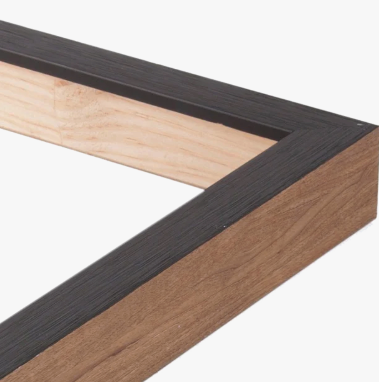 Close-up of a corner of a picture frame, combining dark, textured wood on the top edge with light, natural wood on the inner and outer sides.