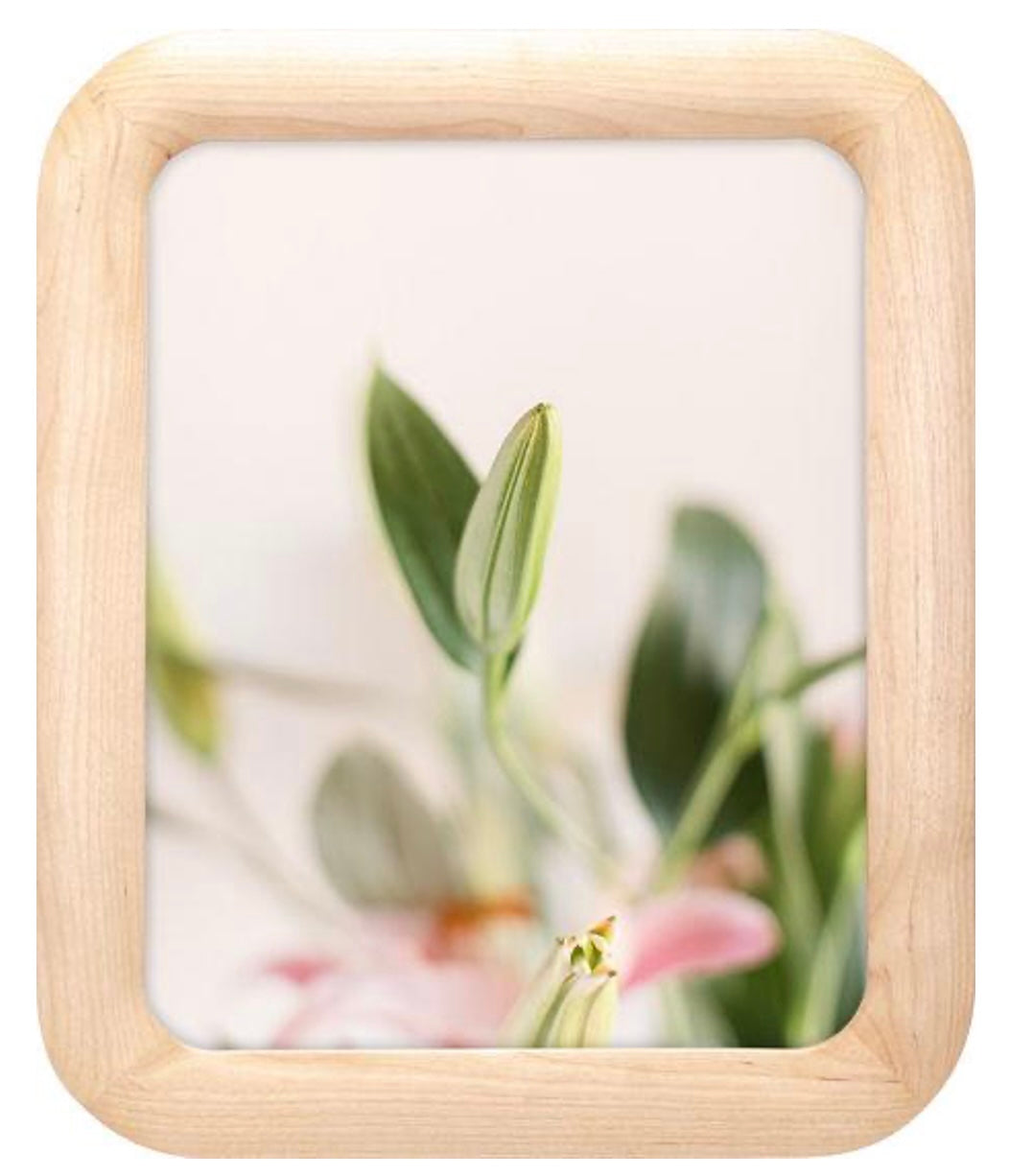 Small wooden photo frame with a blurred floral background