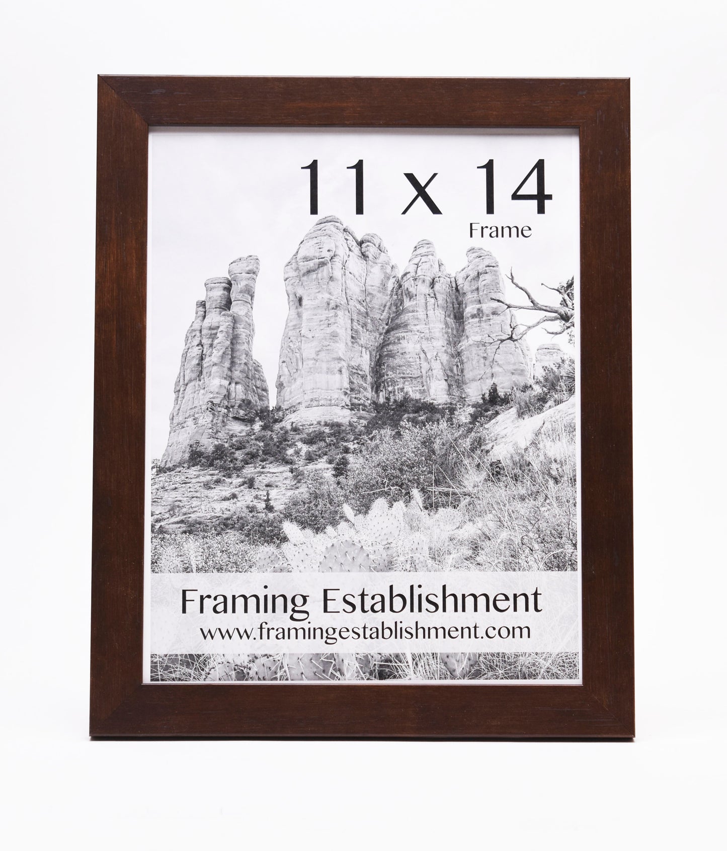 A wooden picture frame holding a black-and-white photo of large rock formations. Text reads "11 x 14 Frame" and "Framing Establishment" with a website link.