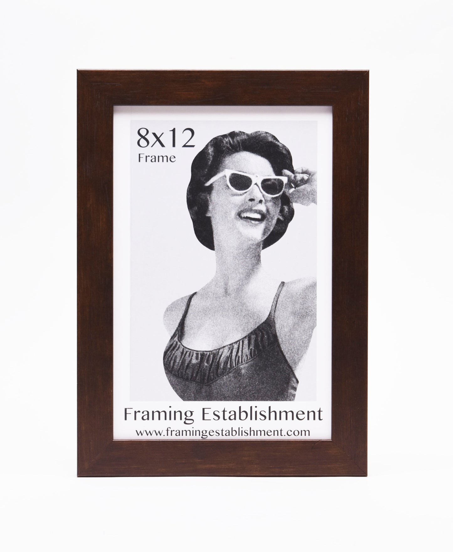 A woman in vintage attire with cat-eye sunglasses smiles in a black and white photo. It's set in a brown 8x12 frame from Framing Establishment.
