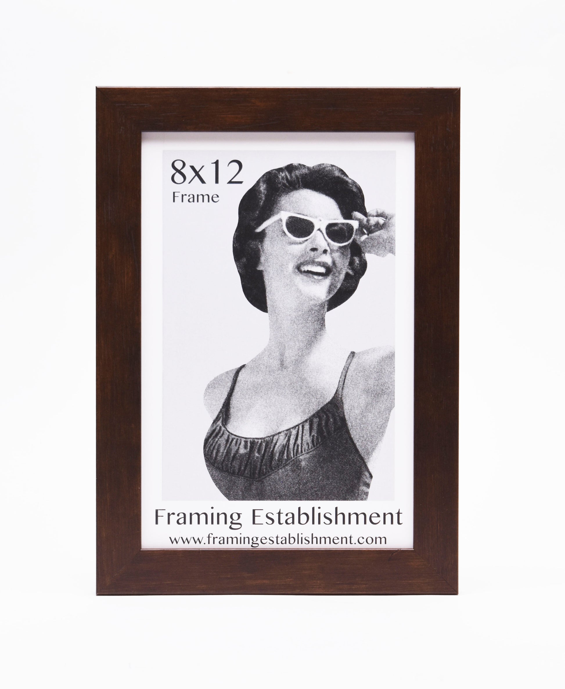 A woman in vintage attire with cat-eye sunglasses smiles in a black and white photo. It's set in a brown 8x12 frame from Framing Establishment.