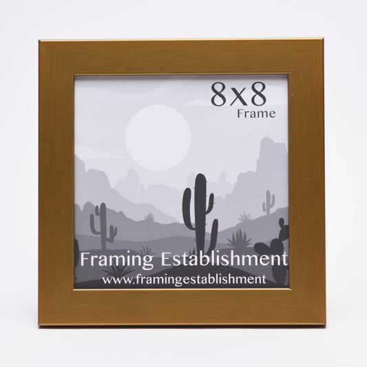 A golden 8x8 picture frame displaying a grayscale desert scene with cacti and distant mountains, creating a calm, natural vibe. Text reads "Framing Establishment."