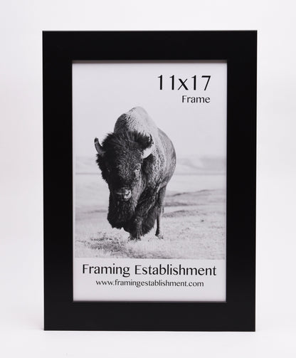 Black frame with a black-and-white photo of a bison in snowy terrain. Text includes "11x17 Frame" and "Framing Establishment" with website link.