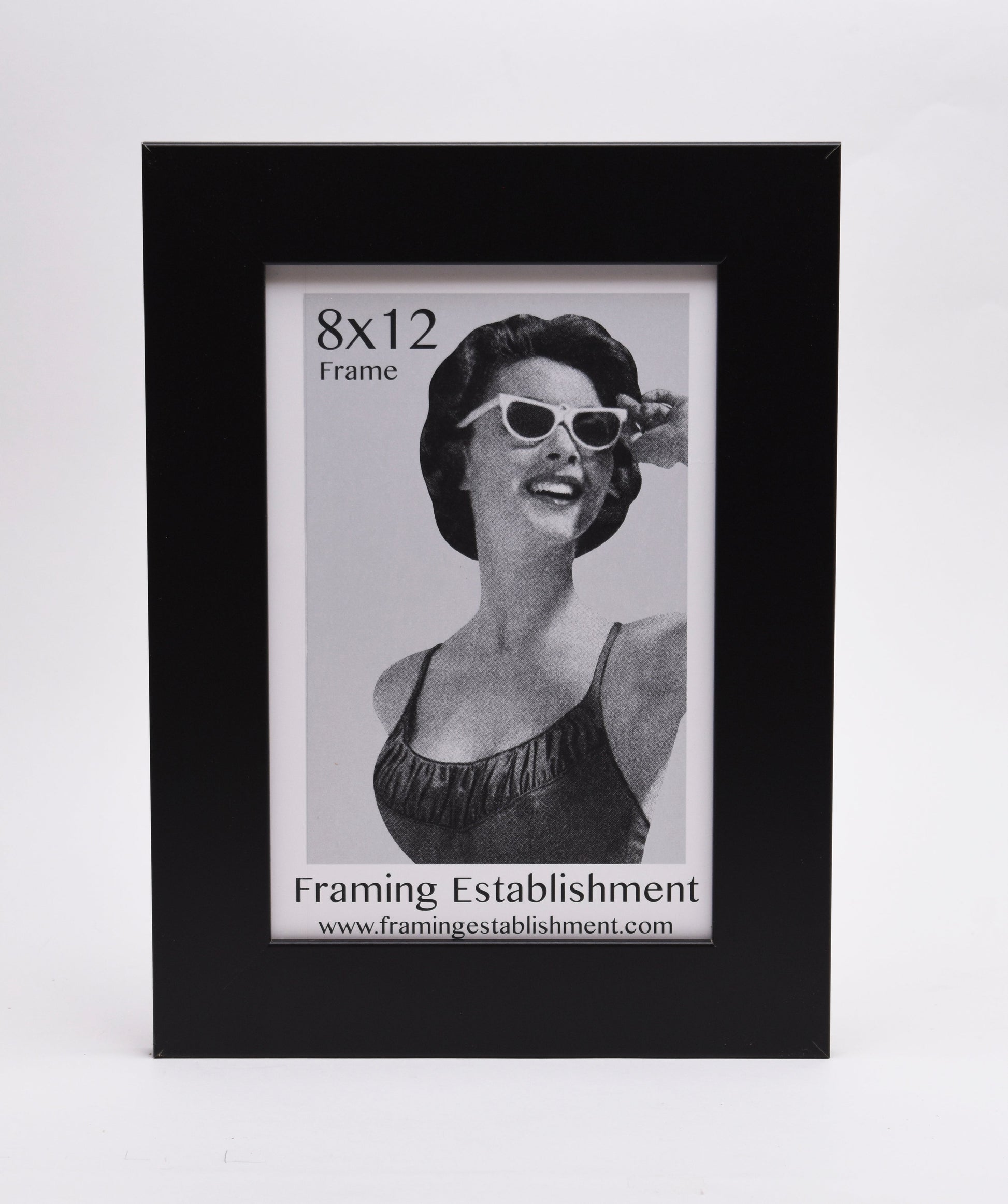 A black frame displays a vintage-style black-and-white photo of a smiling woman in sunglasses. Text reads "8x12 Frame" and "Framing Establishment."