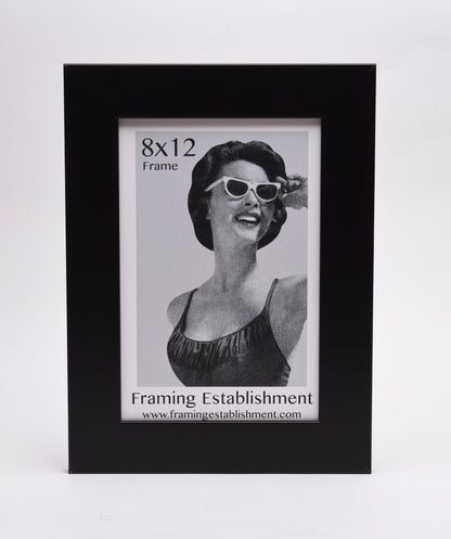 A black frame displays a vintage-style black-and-white photo of a smiling woman in sunglasses. Text reads "8x12 Frame" and "Framing Establishment."