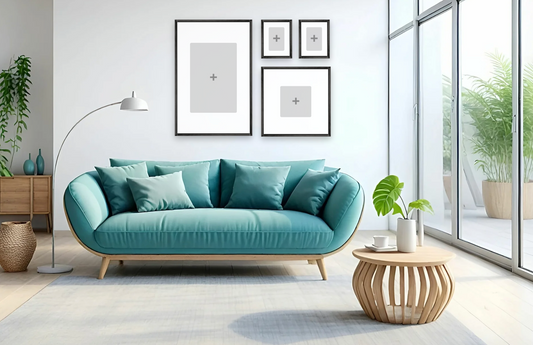 Modern, tranquil living room with a teal sofa adorned with cushions, large windows, potted plants, framed minimalist art, and a sleek floor lamp.