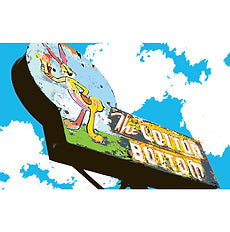 Colorful kite with a design of a person flying over water on a blue sky background.