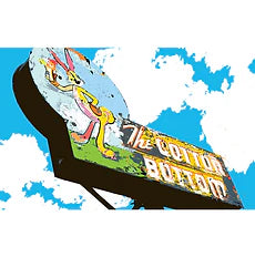 A vintage sign against a bright blue sky with clouds, featuring a cartoon rabbit and the faded text "The Cotton Bottom," evoking nostalgia and whimsy.