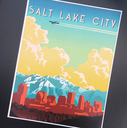 Retro-style poster of Salt Lake City, featuring a colorful skyline against mountains and clouds. An airplane flies above, conveying travel and nostalgia.