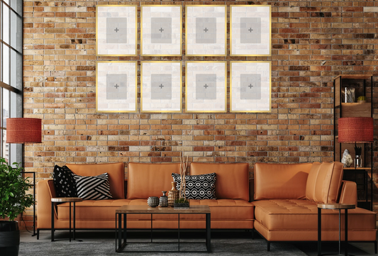 Living room with a brown sectional sofa, decorative pillows, and framed pictures on a brick wall.