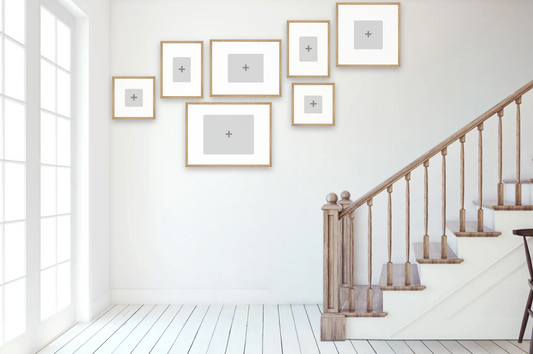 Staircase with wooden railings and white walls with framed pictures.