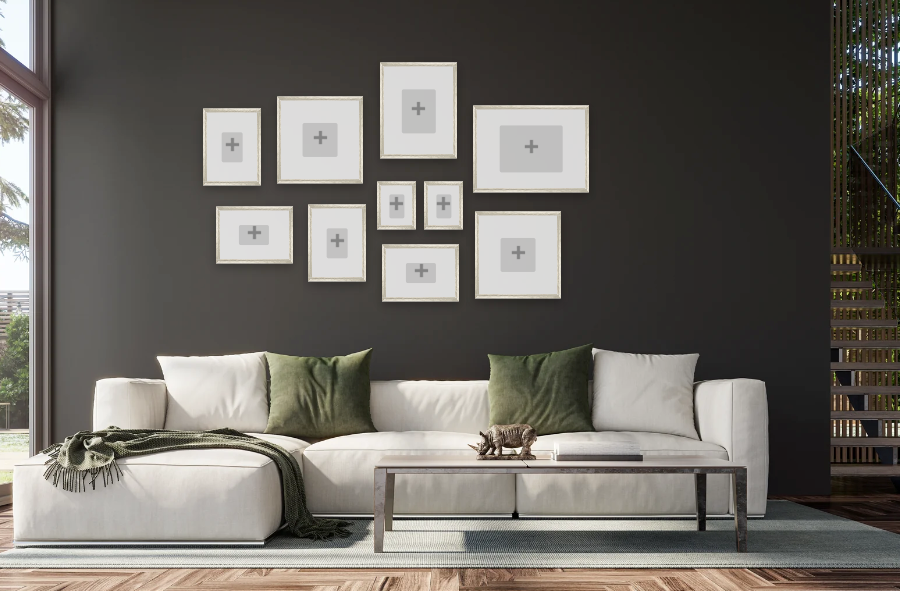 Modern living room with a white sofa, green cushions, and framed pictures on a dark wall.